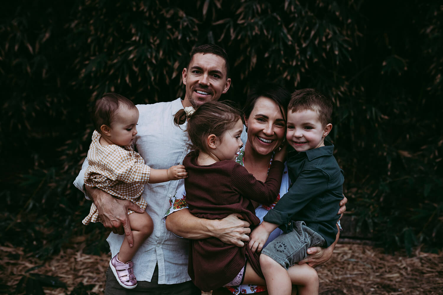 A family of five cuddle with one another.